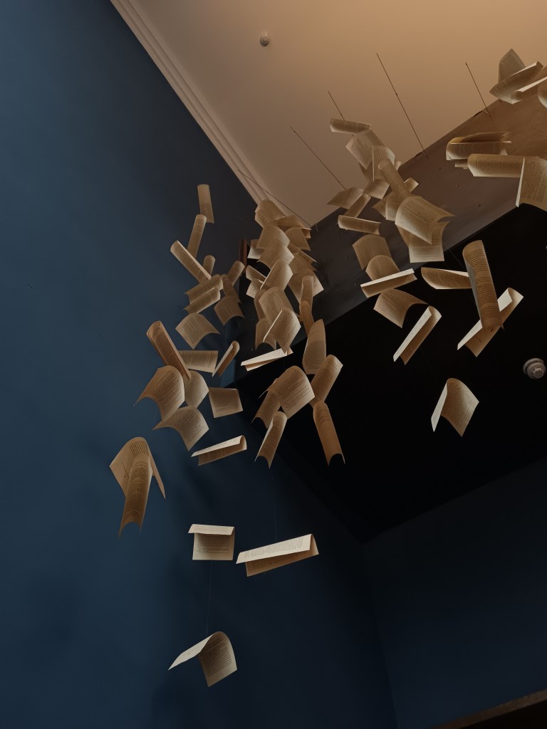 Strings of pages hang from the ceiling