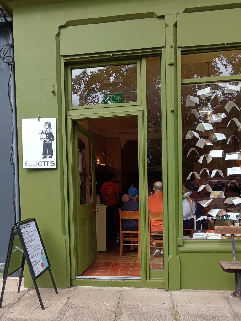 The green shopfront with pages hung in the window