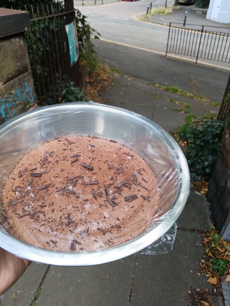 I carry a bowl of chocolate mousse covered in cling film