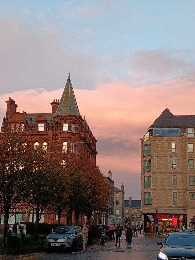 Pink clouds peeking between two Edinburgh buildings