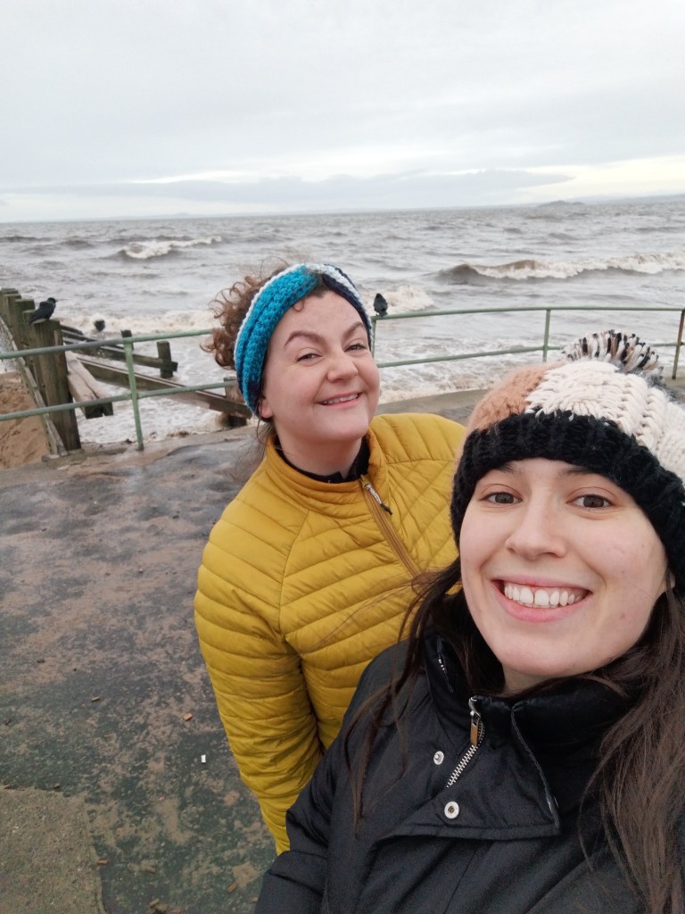 Laura and I smile on a cold beach path