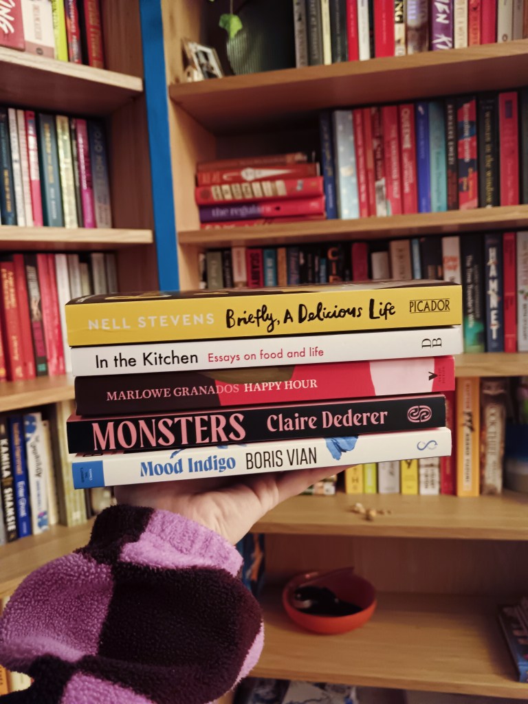 I hold a stack of pretty books