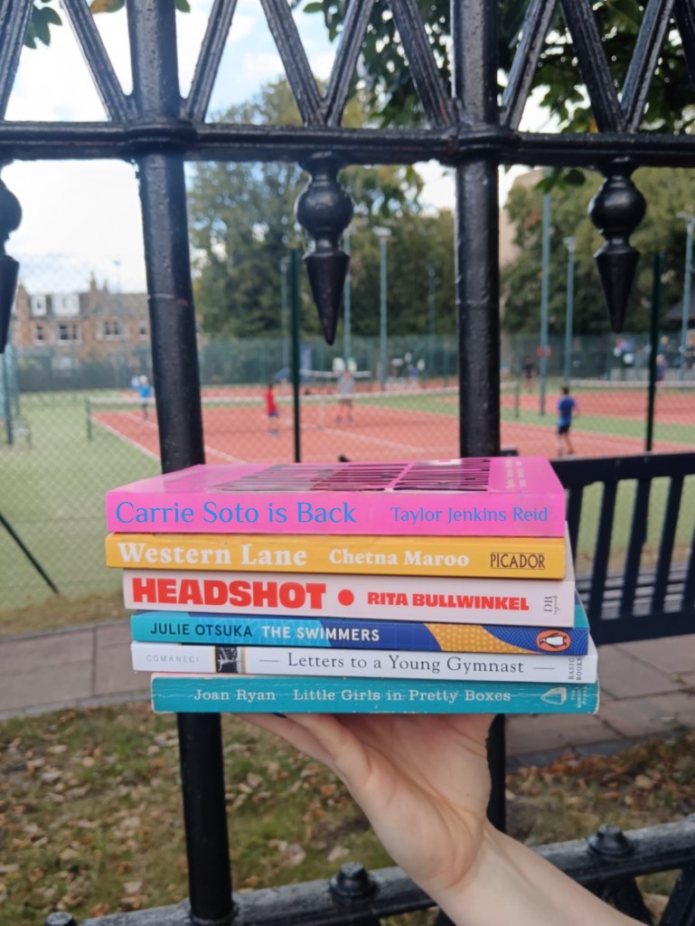A stack of books held in front of a tennis court