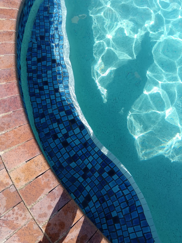 The shining blue tile of the swimming pool