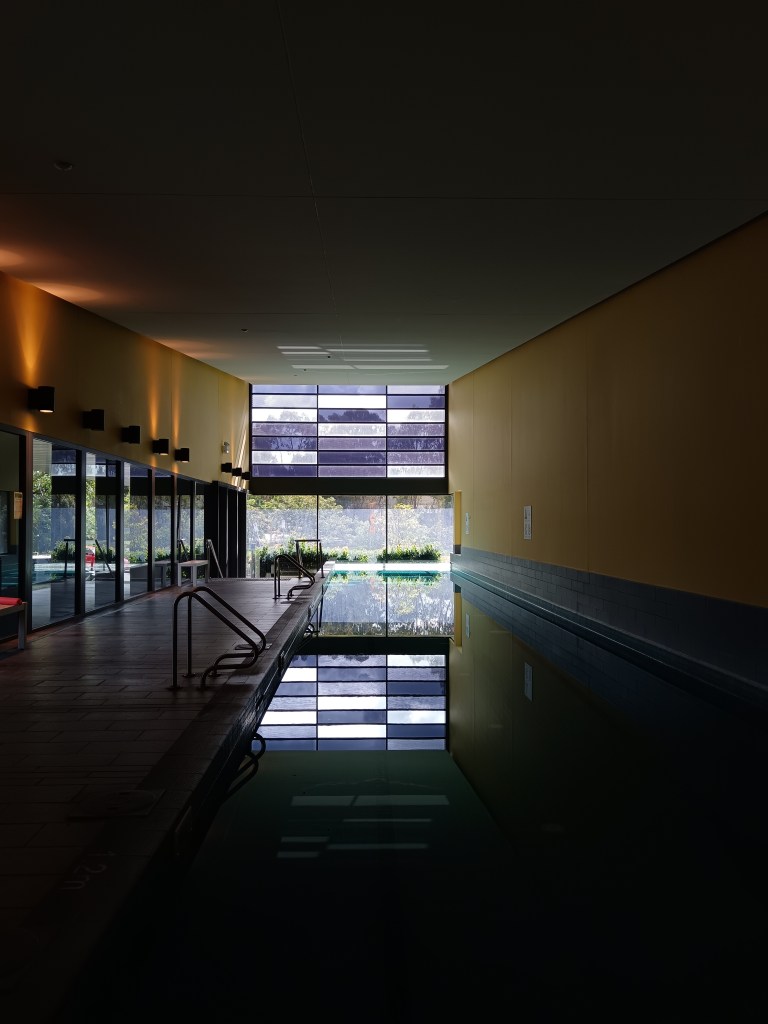 A panelled window dramatically reflects on a wee pool