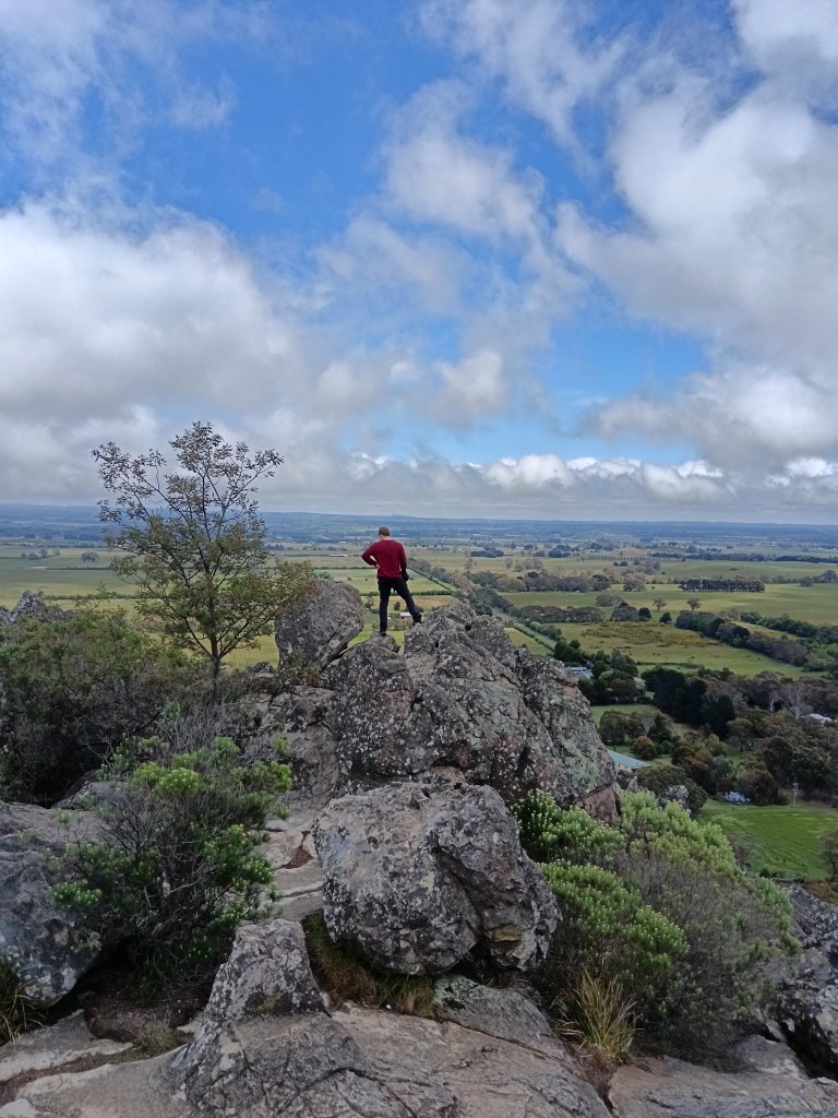 My brother stands on a rock looking out at the view