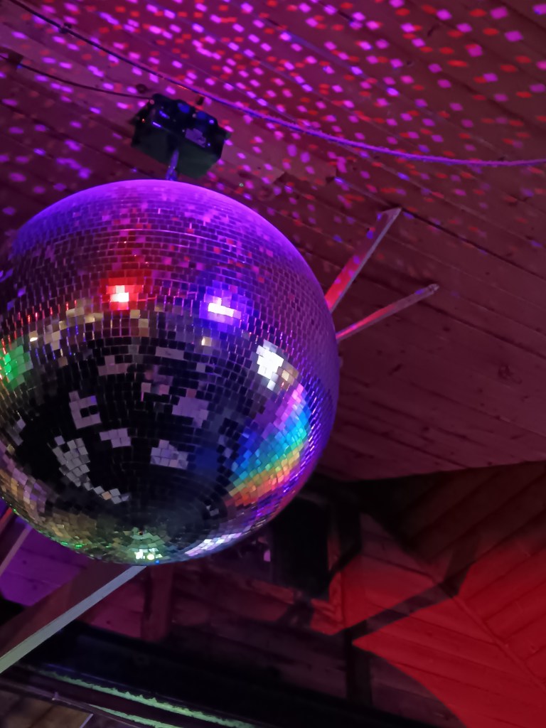 Rainbow lights reflect off a glitter ball