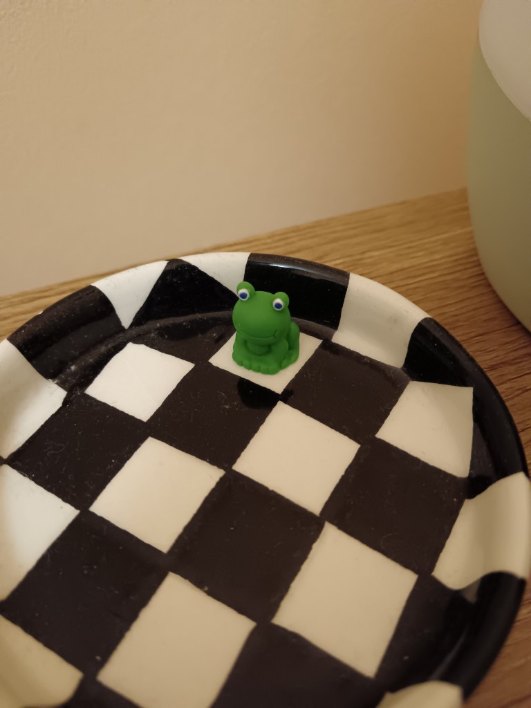 A tiny frog on my checkerboard coaster