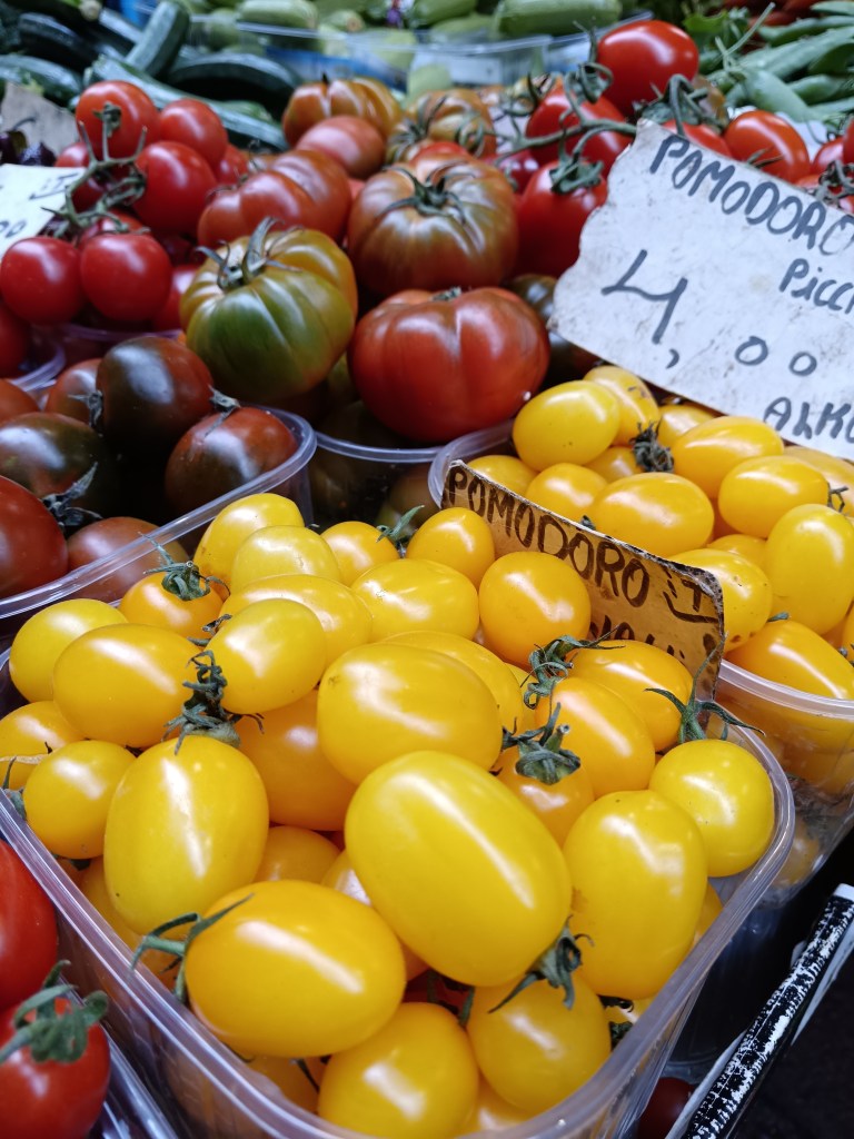 Shiny red and yellow tomatoes on a stall
