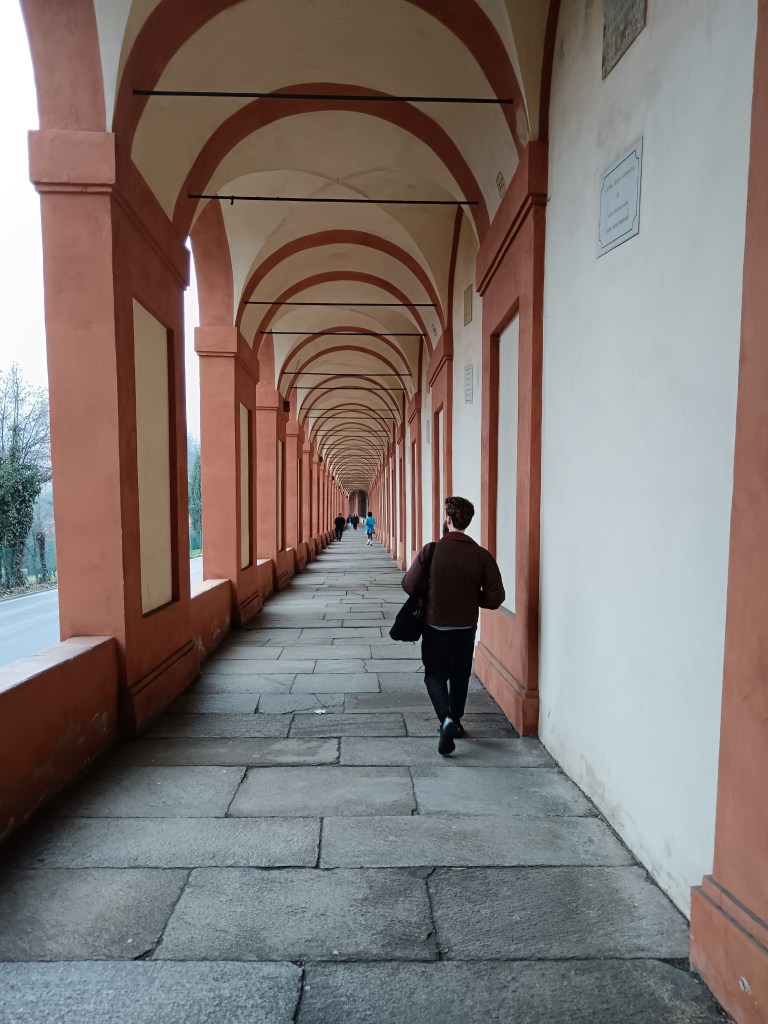 Kit walking down a neverending row of arched porticos