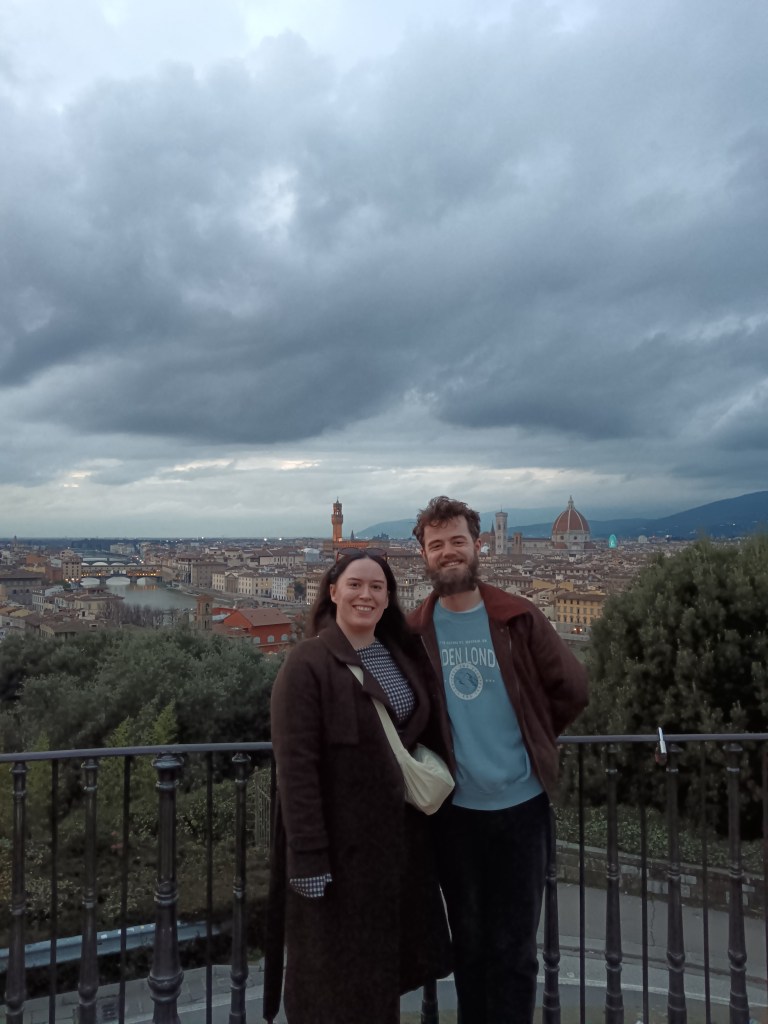 Kit and I stand together at the top of a hill looking over the city