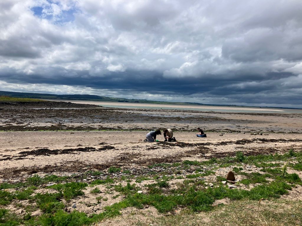 Kit and I kneel on the beach together picking up sea glass