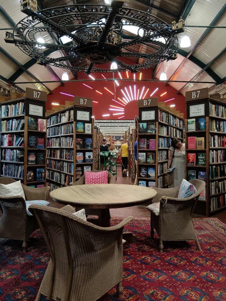 A table and chairs in the centre of rows of book shelves