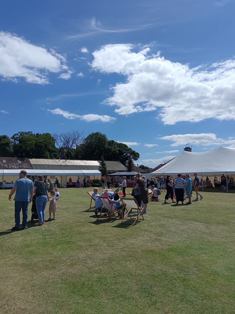 A park with marquees and deckchairs
