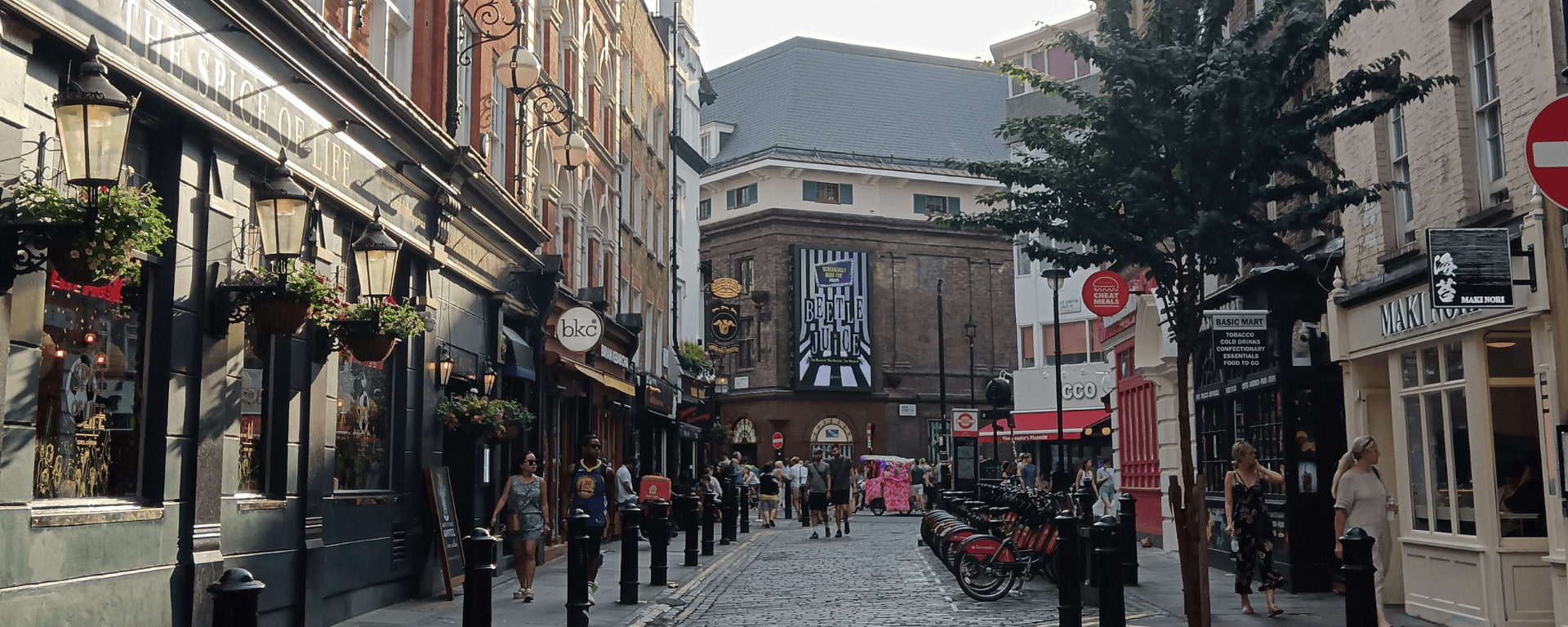 A busy London street leading to a theatre playing Beetlejuice