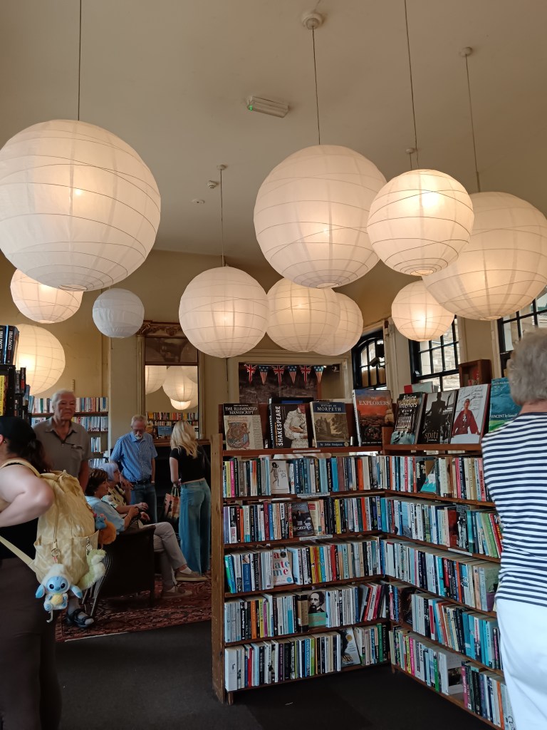 Big paper lanterns hang over shelves full of books