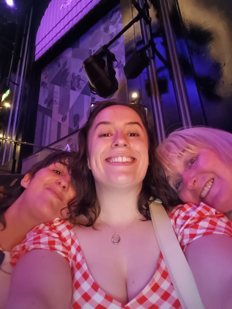 I smile for a selfie with a relative on either of my shoulders