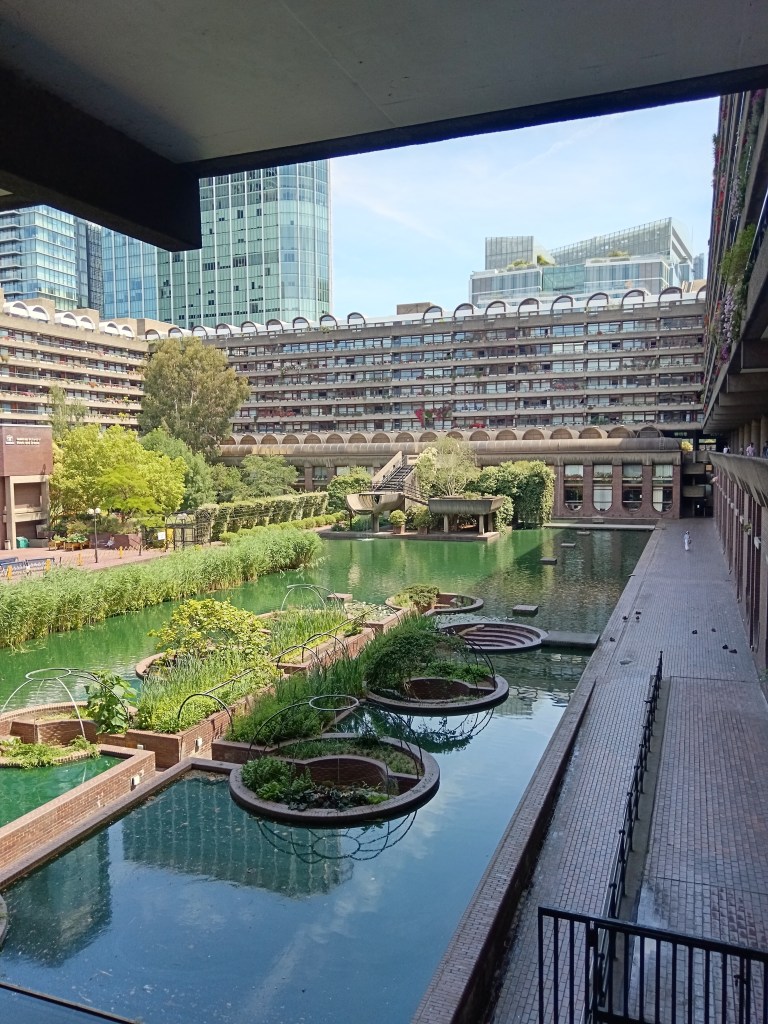 Barbican gardens have brick circles cutting up a green pond and there are lots of plants