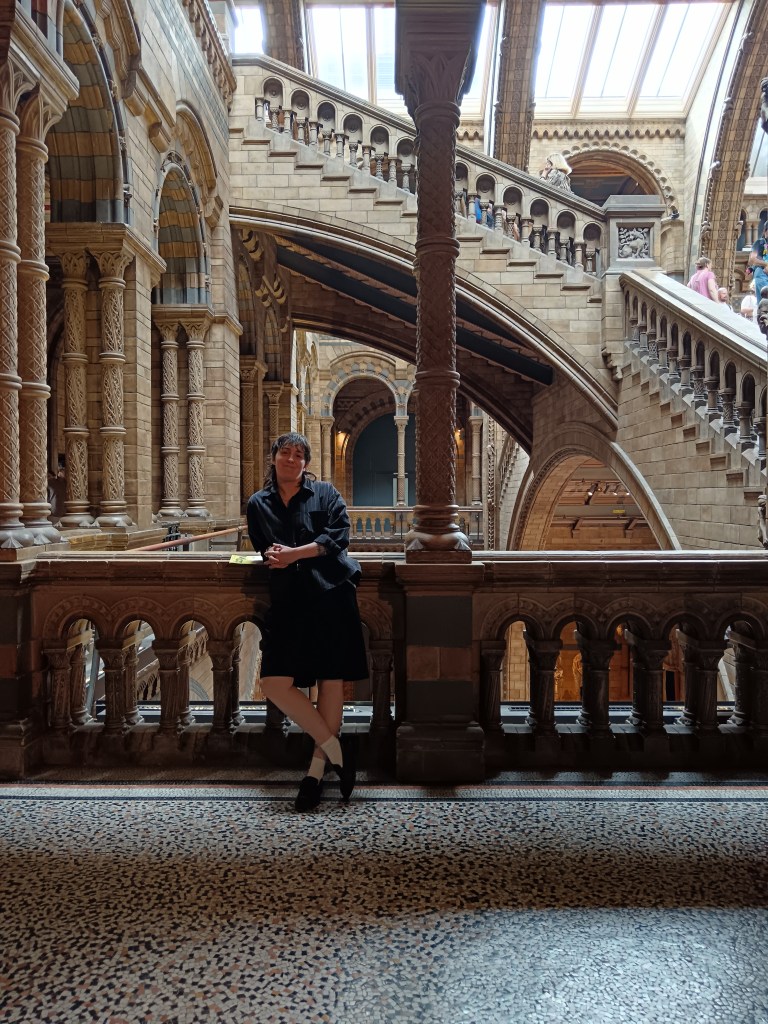 My sister leans on a railing in front of winding stone stairs
