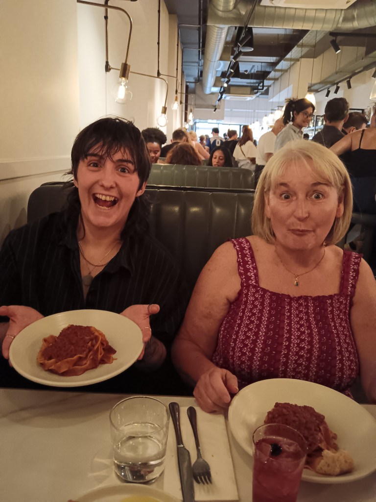 Claire and mum looking excited holding their plates of pasta