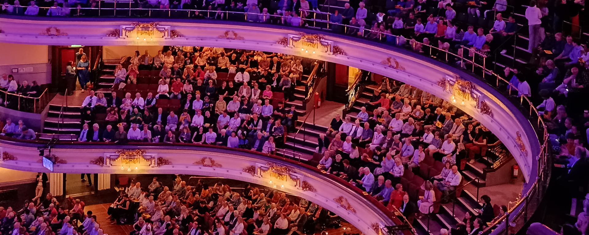 Three floors full of people in a music hall