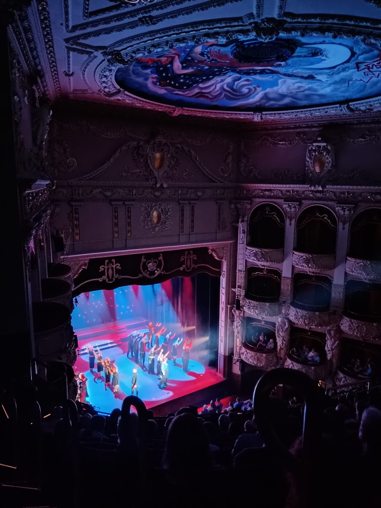 A full audience watch a performance on the grand new stage