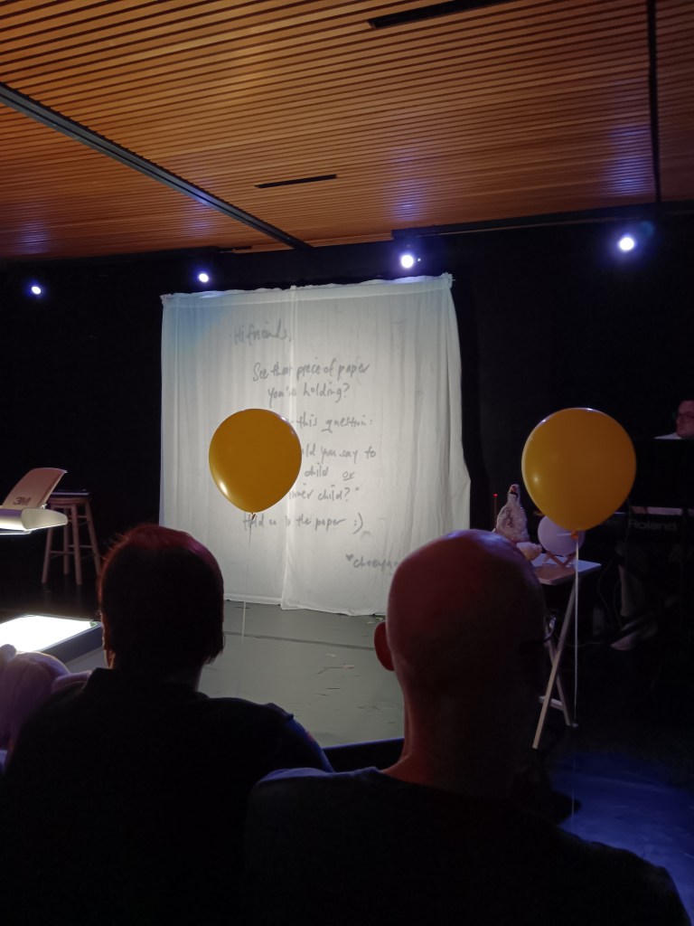 A sheet is projected with a handwritten letter and yellow ballons float