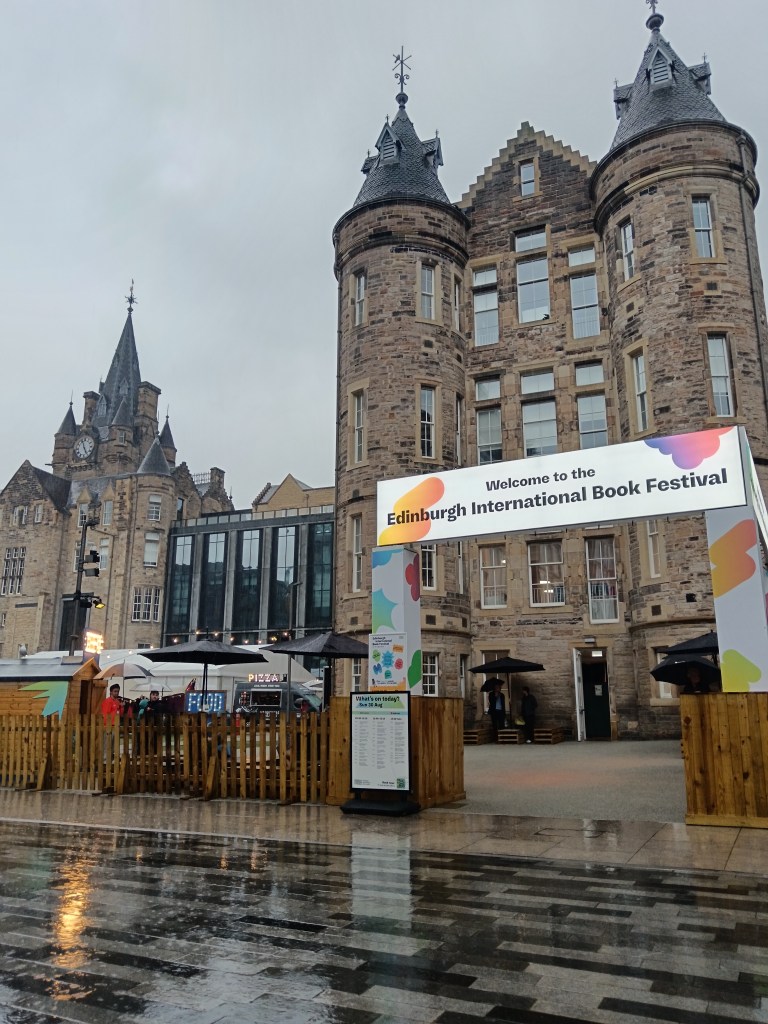 The book festival welcome sign on a rainy day in front of an old building