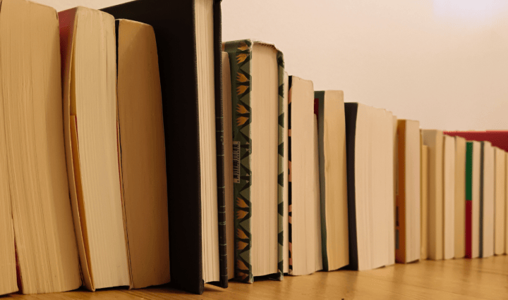 A stack of books lined up on the floor