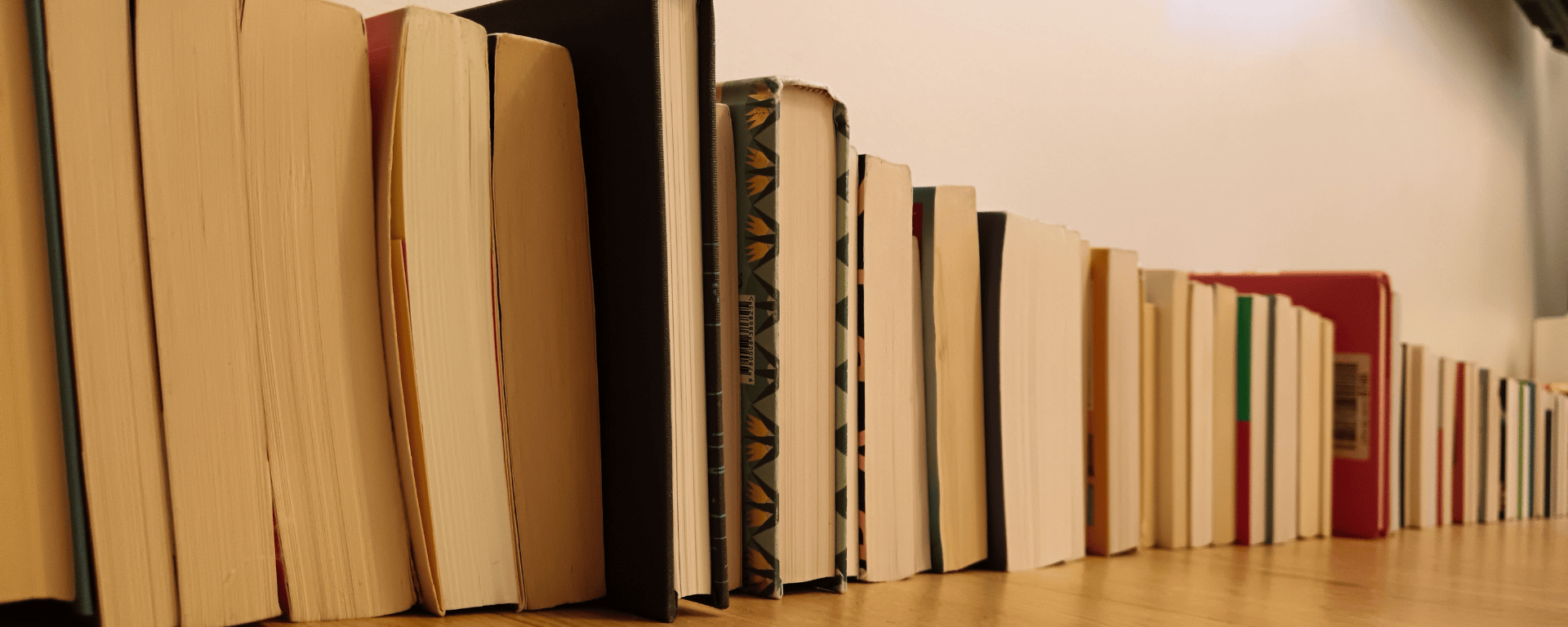 A stack of books lined up on the floor